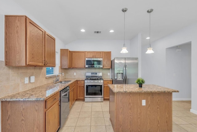 1908 Paradise Ridge Dr, Round Rock, TX 78665 - kitchen featuring appliances with stainless steel finishes, light tile patterned floors, a kitchen island, a sink, and light stone counters