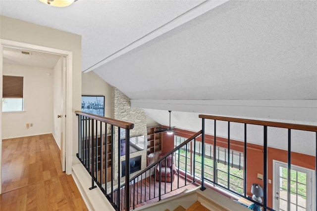 11708 Barrington Way, Austin, TX 78759 - hall featuring wood finished floors, plenty of natural light, an upstairs landing, lofted ceiling, and a textured ceiling