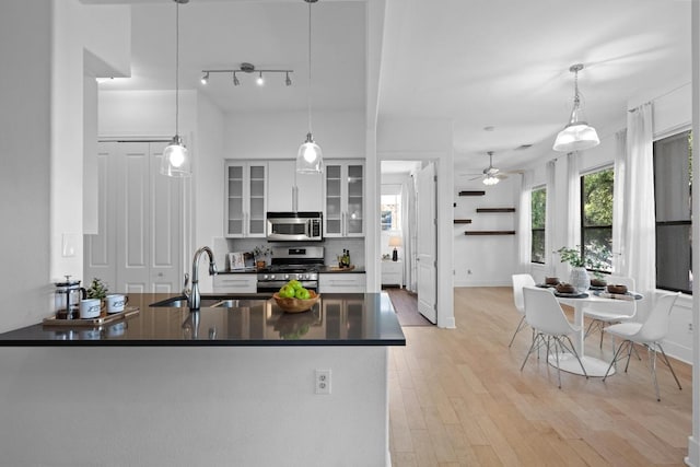 2216 Thornton Rd Unit 221, Austin, TX 78704 - kitchen with stainless steel appliances, a sink, dark countertops, white cabinets, and ceiling fan
