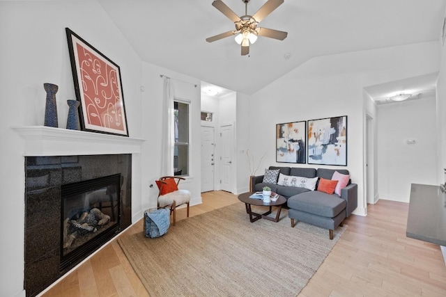 2216 Thornton Rd Unit 221, Austin, TX 78704 - living area featuring light wood-style flooring, vaulted ceiling, a ceiling fan, a tile fireplace, and baseboards