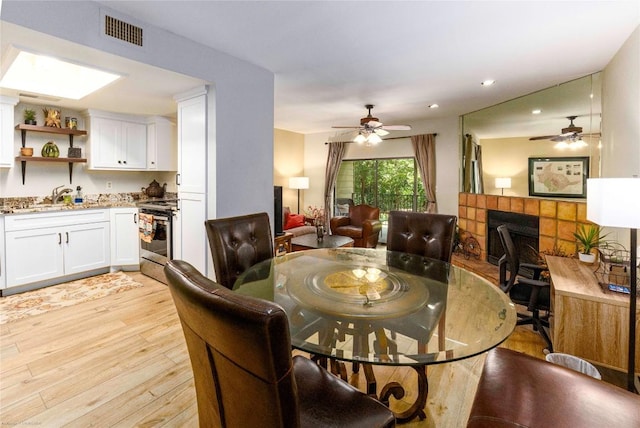 1135 Barton Hills Dr Unit 160, Austin, TX 78704 - dining space with light wood-type flooring, a tile fireplace, ceiling fan, and recessed lighting