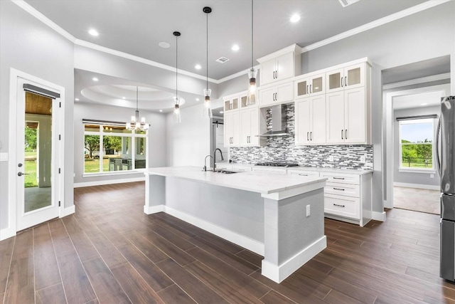 178 Balch Rd, Elgin, TX 78621 - kitchen featuring wall chimney exhaust hood, decorative backsplash, plenty of natural light, an island with sink, and ornamental molding