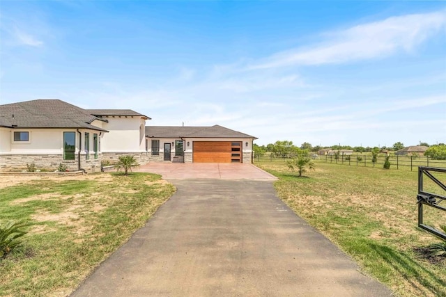 178 Balch Rd, Elgin, TX 78621 - view of front of home with stone siding, asphalt driveway, stucco siding, and a garage