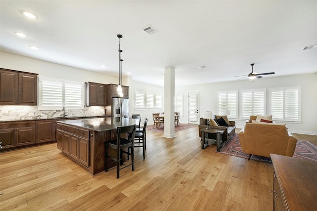 192 Call Dr, Austin, TX 78737 - kitchen featuring stainless steel fridge, a breakfast bar, ceiling fan, a kitchen island, and light wood-style floors