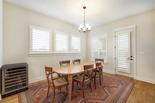 192 Call Dr, Austin, TX 78737 - dining area with wine cooler, a chandelier, light wood-style floors, and baseboards
