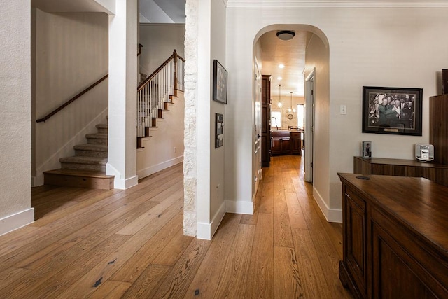 110 Saint Richie Ln, Austin, TX 78737 - corridor with light wood-type flooring, stairway, baseboards, and arched walkways