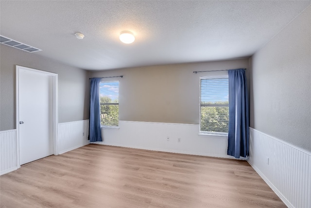 14 Verde Ranch Loop, Leander, TX 78641 - spare room featuring a wainscoted wall, a textured ceiling, wood finished floors, and a smoke detector