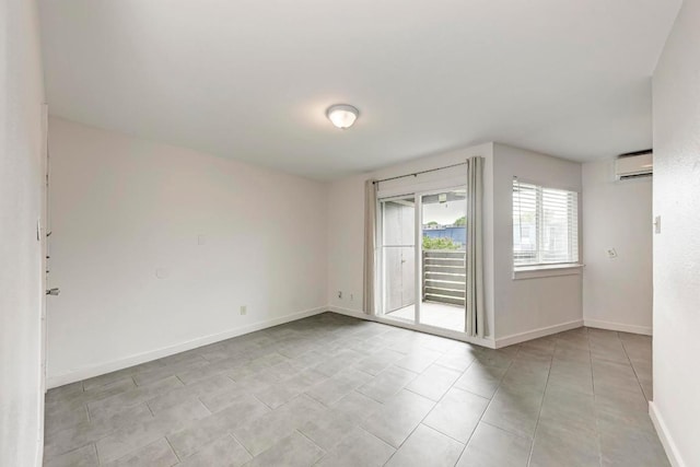 1840 Burton Dr Unit 102, Austin, TX 78741 - empty room featuring a wall unit AC, light tile patterned flooring, and baseboards