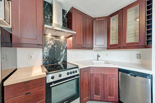 1840 Burton Dr Unit 102, Austin, TX 78741 - kitchen with stainless steel appliances, wall chimney range hood, light countertops, and glass insert cabinets