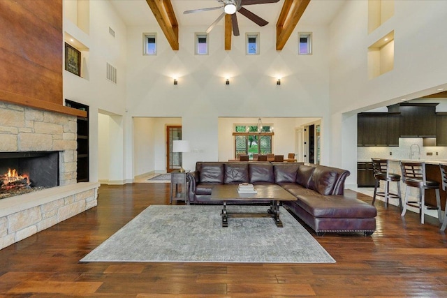 1101 Sprague Ln, West Lake Hills, TX 78746 - living area with a ceiling fan, a high ceiling, hardwood / wood-style flooring, a fireplace, and beamed ceiling