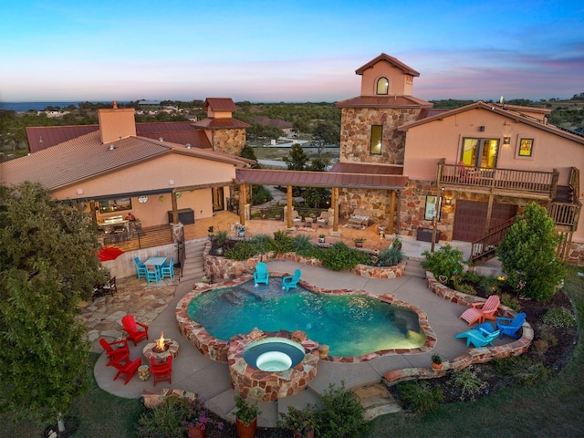 281 Cedar Mountain Dr, Marble Falls, TX 78654 - pool at dusk with a patio, a pool with connected hot tub, and stairs
