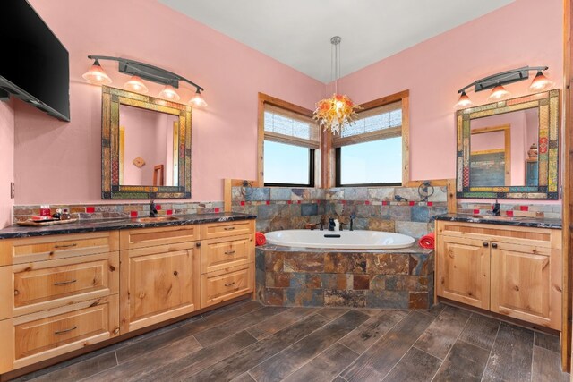 281 Cedar Mountain Dr, Marble Falls, TX 78654 - bathroom with two vanities, a garden tub, and wood finished floors