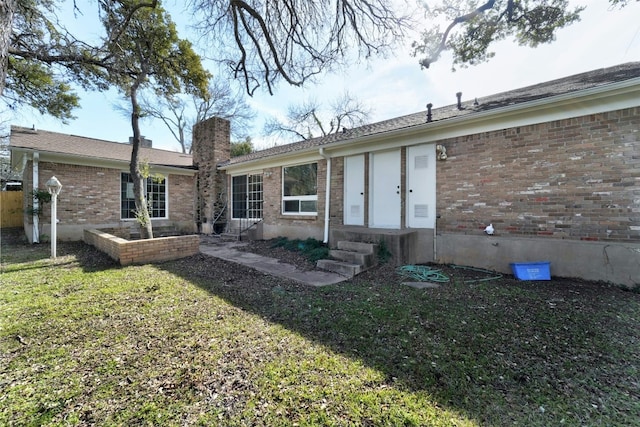 4020 Far W Blvd, Austin, TX 78731 - rear view of property with brick siding, a chimney, a lawn, and entry steps