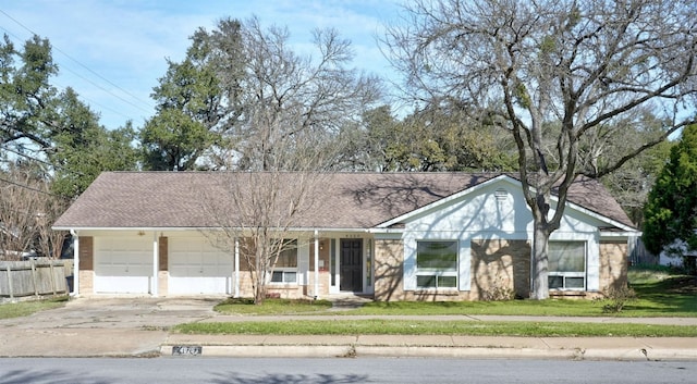 4020 Far W Blvd, Austin, TX 78731 - view of front of house featuring driveway, a garage, brick siding, and a shingled roof