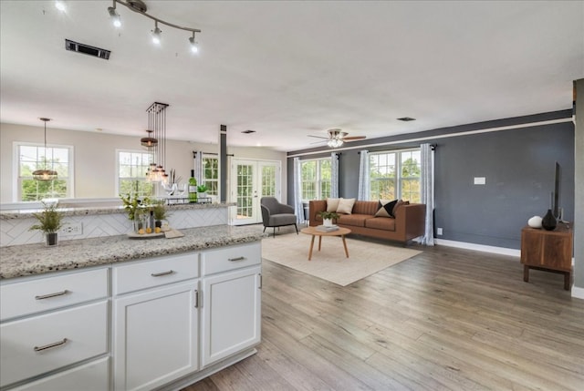 8204 Williamson Creek Dr, Austin, TX 78736 - kitchen featuring white cabinetry, tasteful backsplash, light wood-style floors, and healthy amount of natural light