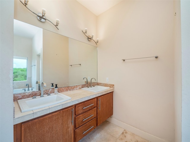 14410 Hunters Pass, Austin, TX 78734 - bathroom featuring double vanity, tile patterned floors, and baseboards