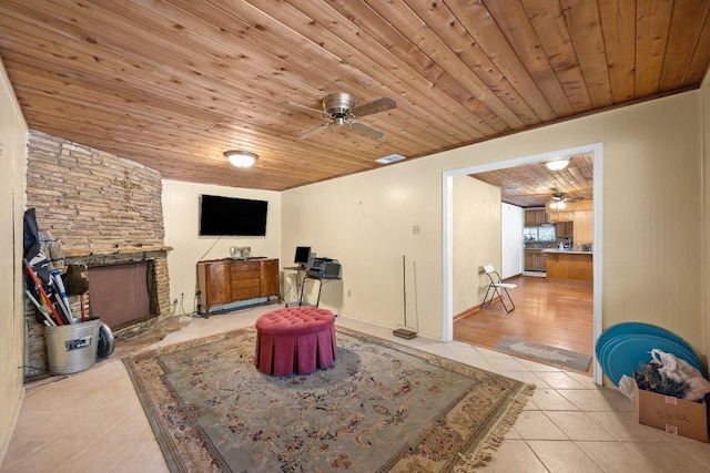 217 S Wilson St, San Marcos, TX 78666 - tiled living area with wood ceiling, a fireplace, and a ceiling fan