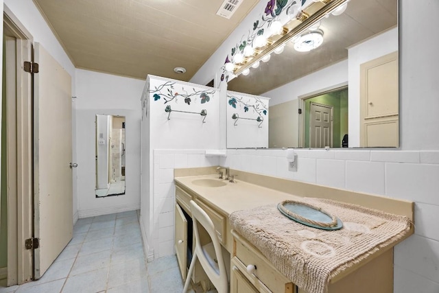 217 S Wilson St, San Marcos, TX 78666 - bathroom with tile patterned floors, double vanity, and tile walls