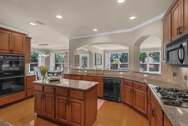 12709 Pinto Chase Ct, Austin, TX 78732 - kitchen with black appliances, a sink, brown cabinetry, crown molding, and light wood-style floors