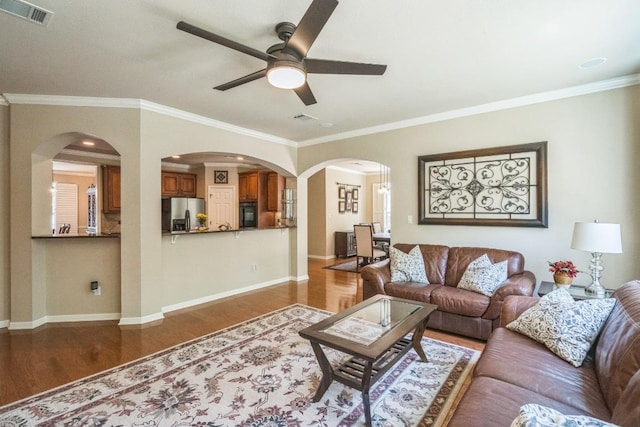 12709 Pinto Chase Ct, Austin, TX 78732 - living room with ceiling fan, wood finished floors, crown molding, baseboards, and arched walkways