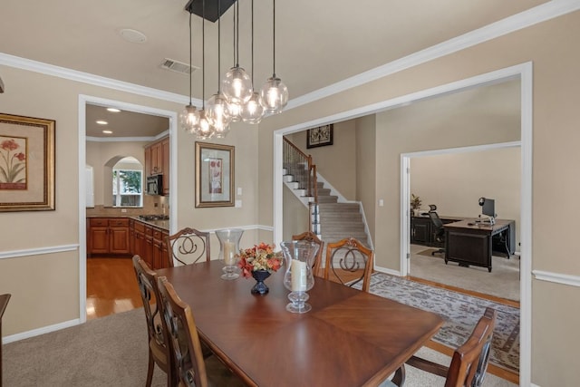 12709 Pinto Chase Ct, Austin, TX 78732 - dining area featuring light colored carpet, stairs, ornamental molding, arched walkways, and a chandelier