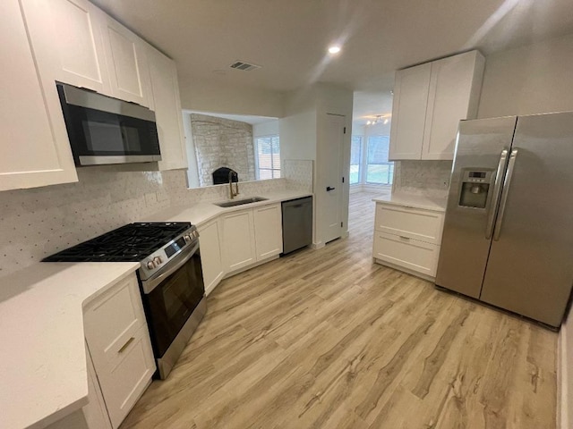 8527 Birmingham Dr, Austin, TX 78748 - kitchen with appliances with stainless steel finishes, tasteful backsplash, light wood-style floors, and light countertops