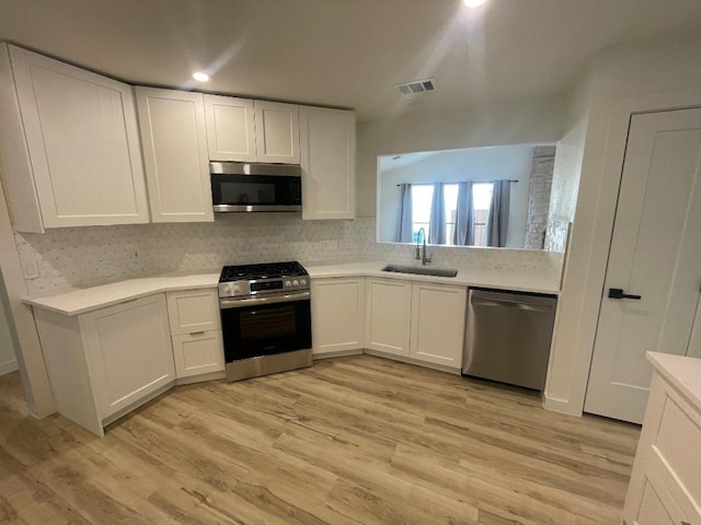 8527 Birmingham Dr, Austin, TX 78748 - kitchen featuring stainless steel appliances, white cabinetry, light countertops, and light wood-style floors