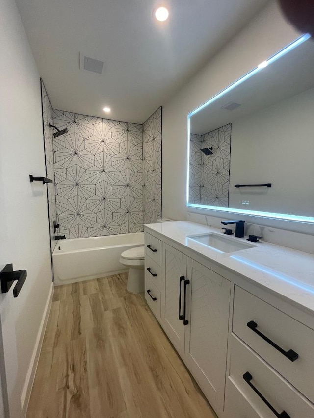 8527 Birmingham Dr, Austin, TX 78748 - bathroom featuring toilet, vanity, wood finished floors,  shower combination, and recessed lighting