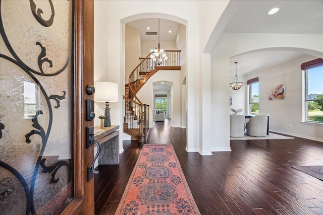 331 Littleton Dr, Austin, TX 78737 - foyer with arched walkways, dark wood-style flooring, stairs, a chandelier, and a towering ceiling