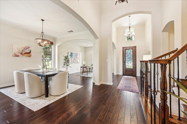 331 Littleton Dr, Austin, TX 78737 - foyer entrance with a chandelier, arched walkways, dark wood-style floors, baseboards, and ornamental molding
