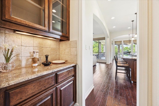 331 Littleton Dr, Austin, TX 78737 - bar area featuring arched walkways, tasteful backsplash, dark wood-style floors, baseboards, and recessed lighting