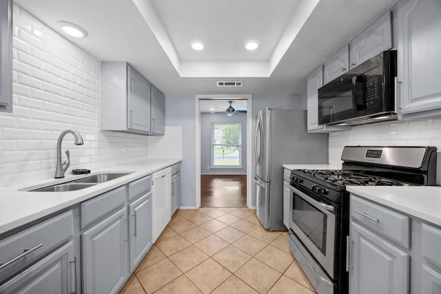1301 S Meadows Dr, Austin, TX 78758 - kitchen with stainless steel gas stove, black microwave, a sink, gray cabinets, and dishwasher