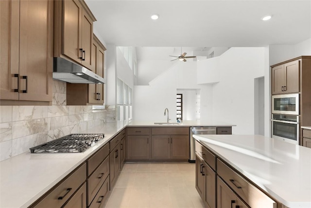 2705 Sage Ranch Dr Unit 20, Leander, TX 78641 - kitchen with stainless steel appliances, under cabinet range hood, backsplash, a ceiling fan, and light countertops
