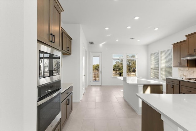 2705 Sage Ranch Dr Unit 20, Leander, TX 78641 - kitchen with appliances with stainless steel finishes, under cabinet range hood, recessed lighting, light countertops, and decorative backsplash