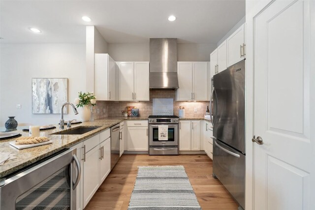 2520 Bluebonnet Ln Unit 58, Austin, TX 78704 - kitchen featuring appliances with stainless steel finishes, wall chimney exhaust hood, beverage cooler, light stone countertops, and decorative backsplash