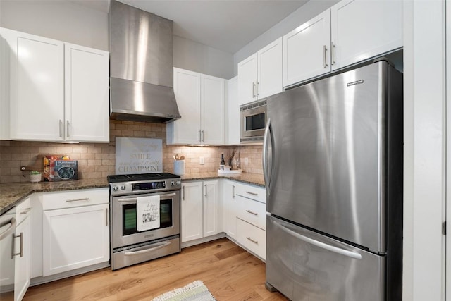 2520 Bluebonnet Ln Unit 58, Austin, TX 78704 - kitchen with appliances with stainless steel finishes, wall chimney range hood, white cabinets, and stone countertops