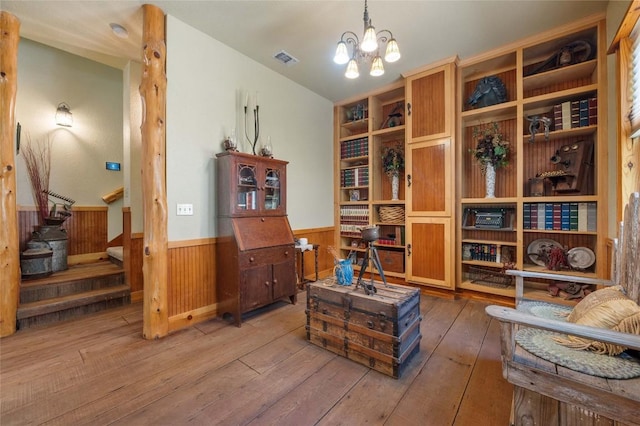 136 Red Fox Ln, Bastrop, TX 78602 - living area featuring a wainscoted wall, wood-type flooring, a chandelier, and wooden walls