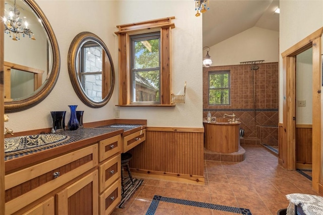 136 Red Fox Ln, Bastrop, TX 78602 - bathroom featuring healthy amount of natural light, vanity, wainscoting, a tile shower, and vaulted ceiling