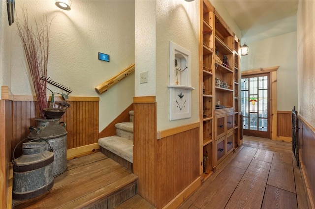 136 Red Fox Ln, Bastrop, TX 78602 - stairway with a wainscoted wall, wood walls, and hardwood / wood-style flooring