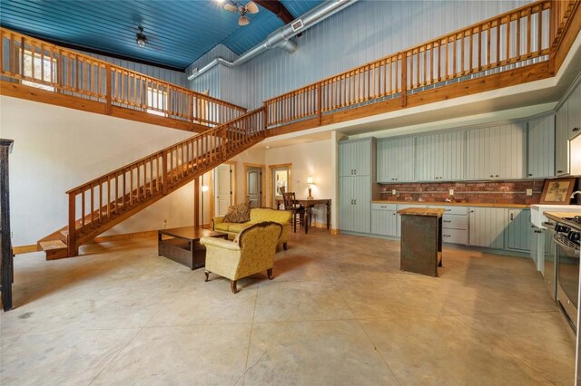 136 Red Fox Ln, Bastrop, TX 78602 - living area with a high ceiling, stairway, and concrete flooring