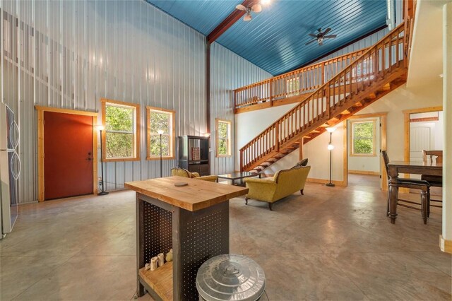 136 Red Fox Ln, Bastrop, TX 78602 - living area featuring high vaulted ceiling, stairs, concrete flooring, a ceiling fan, and baseboards