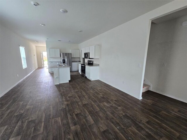 12324 Token Trl, Elgin, TX 78621 - kitchen with stainless steel appliances, dark wood-type flooring, white cabinetry, a kitchen island with sink, and baseboards