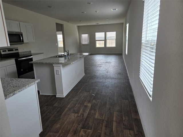 12324 Token Trl, Elgin, TX 78621 - kitchen featuring stainless steel appliances, a sink, dark wood-style flooring, white cabinets, and light stone countertops