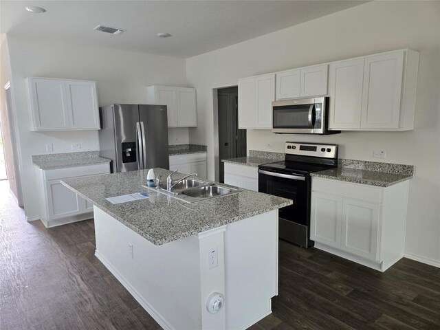 12324 Token Trl, Elgin, TX 78621 - kitchen with stainless steel appliances, a sink, dark wood-style flooring, and white cabinets
