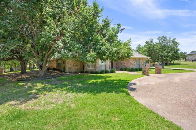 1204 Fairway Cir, Salado, TX 76571 - obstructed view of property featuring a front lawn and brick siding