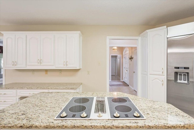 1204 Fairway Cir, Salado, TX 76571 - kitchen featuring black electric stovetop, built in refrigerator, white cabinetry, and light stone countertops