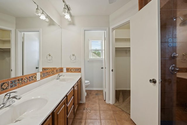 12508 Terra Nova Ln, Austin, TX 78727 - bathroom with toilet, double vanity, a walk in closet, a tile shower, and tile patterned floors
