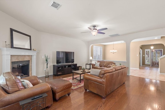 306 Water Oak Dr, Cedar Park, TX 78613 - living area featuring arched walkways, a ceiling fan, wood-type flooring, a tiled fireplace, and baseboards