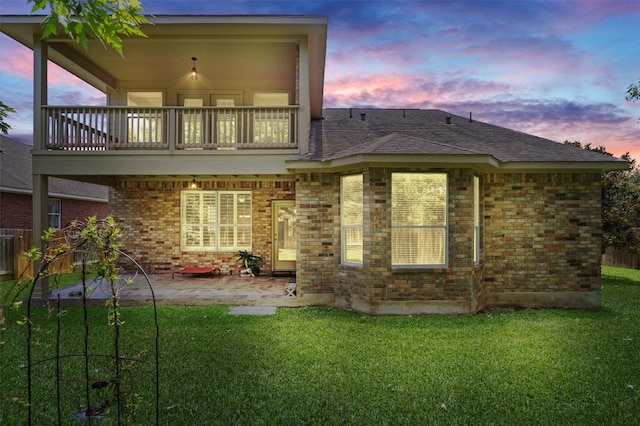 306 Water Oak Dr, Cedar Park, TX 78613 - back of house at dusk with a balcony, a patio area, brick siding, and roof with shingles