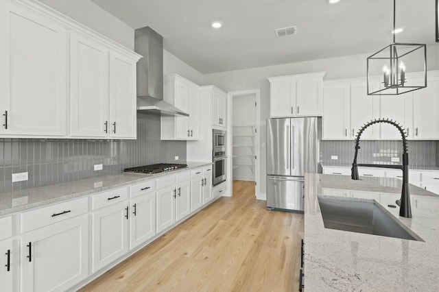 17109 Howdy Way, Manor, TX 78653 - kitchen featuring stainless steel appliances, a sink, wall chimney exhaust hood, white cabinets, and tasteful backsplash